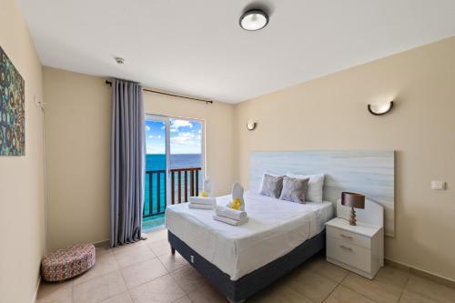 Un dormitorio con una cama con vista al mar. en Heerlijk appartement met prachtig uitzicht op zee!, en Jan Thiel