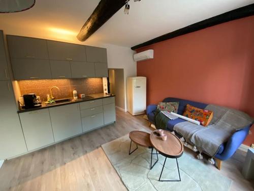 un salon avec un canapé bleu et une table dans l'établissement T2 douillet rénové hyper centre, à Nîmes