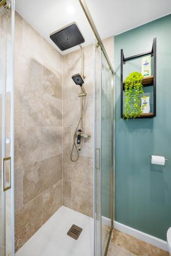 une douche avec une porte vitrée dans une salle de bain dans l'établissement Cosy & Chill Appartements - Superbe vue mer, Wifi & Clim, à Cagnes-sur-Mer