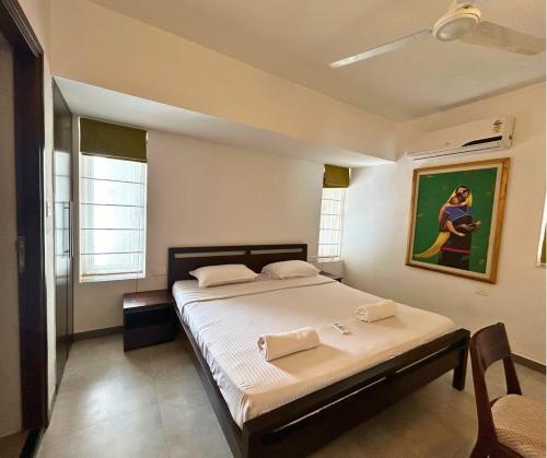 a bedroom with a bed and a painting on the wall at Jungle Hut-Annabelle's Beach Apartments at Bernard Simao,Calangute,Goa in Candolim