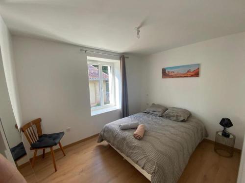 une chambre avec un lit, une chaise et une fenêtre dans l'établissement Appartement coquet avec 3 chambres en face des pistes de ski, à Gérardmer