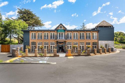 a large brick building with a fence in a parking lot at Elegant Santa Rosa Getaway at Historic Stonehouse! in Santa Rosa