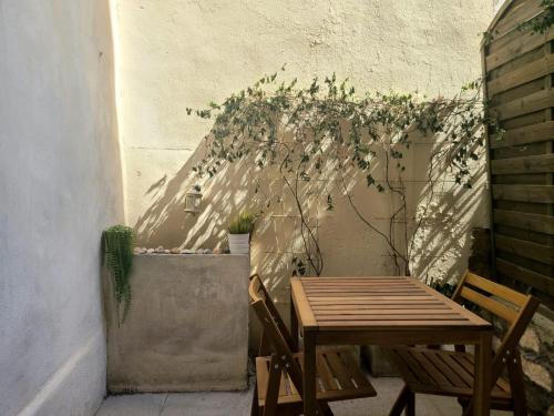 une table et des chaises sur une terrasse avec une plante dans l'établissement Superbe T2 Spacieux Centre-ville avec extérieur, à Montpellier