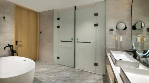 a bathroom with a tub and a sink and a shower at Holiday Inn Shenzhen Nanshan by IHG in Shenzhen