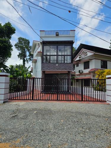 una casa con una puerta roja y una valla en Eon Nest, en Chengannūr