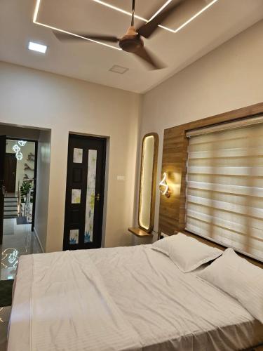 Un dormitorio con una cama y un ventilador de techo. en Eon Nest, en Chengannūr
