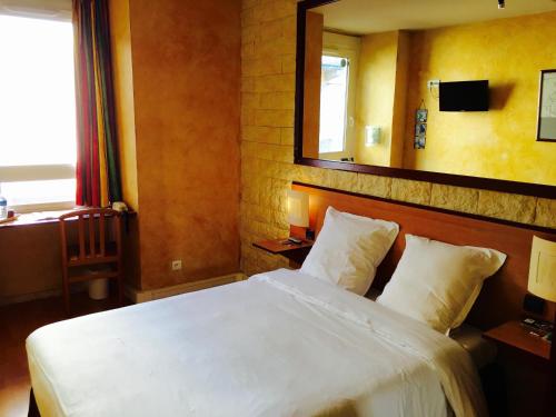 a bedroom with a white bed and a mirror at Hôtel Bosquet Pau Centre - Self Check In Budget Hotel in Pau
