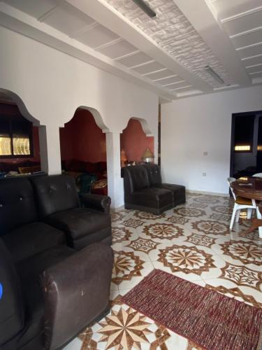 a living room with a couch and a tv at Maison Entière Reposante à 5km de Oualidia in El Akarta