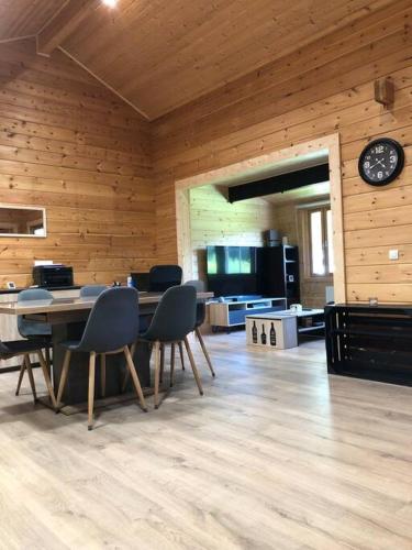 une chambre avec une table, des chaises et une horloge dans l'établissement Le Cottage de l etang, à Bourbourg