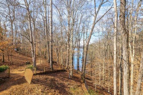a wooden bench sitting in the middle of a forest at Lakeview with Dock and king bed Gainesville in Oscarville