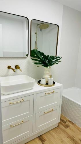 a bathroom with a white sink and a mirror at Piso Porta do Sol in Ribeira