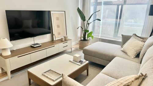 Una sala de estar con un televisor de pantalla plana grande. en Piso Porta do Sol, en Ribeira