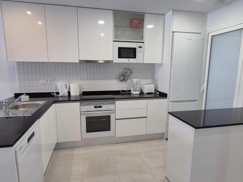 a kitchen with white cabinets and black counter tops at Casa Ariella in San Juan de los Terreros