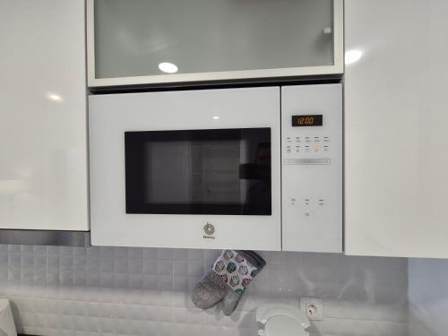 a microwave oven in a kitchen with a pair of shoes at Casa Ariella in San Juan de los Terreros