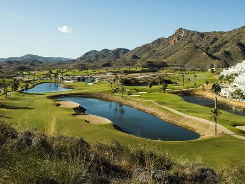 a view of a golf course with a pond at Casa Ariella in San Juan de los Terreros