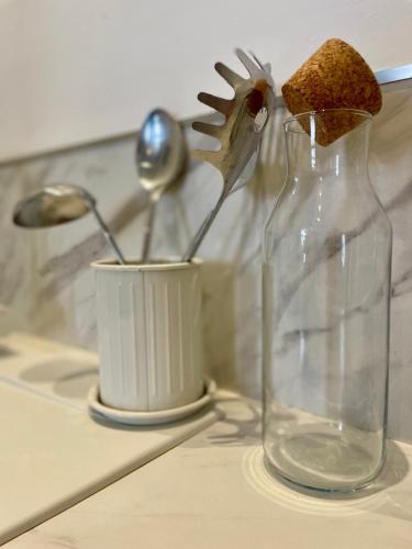 un vase en verre assis sur un comptoir de cuisine avec des cuillères dans l'établissement LE CLOS DE SAINT JO - Dijon centre T3, à Dijon