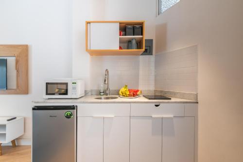 a kitchen with white cabinets and a sink and a microwave at Quiet Stylish Studio, Smart Tv, Six Flags 1k in Mexico City