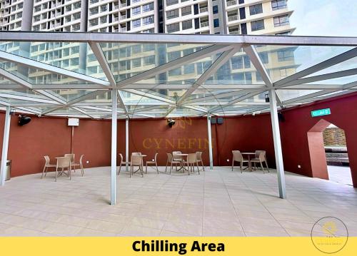 a patio with tables and chairs in front of a building at SOHO Suites Sunsuria Setia Alam at Shah Alam in Shah Alam