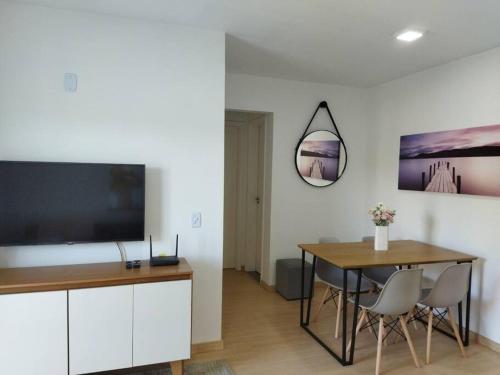 Bom SucessoにあるApartamento em condomínio Nogueira Petrópolis Rj #1のダイニングルーム(テーブル、大画面テレビ付)