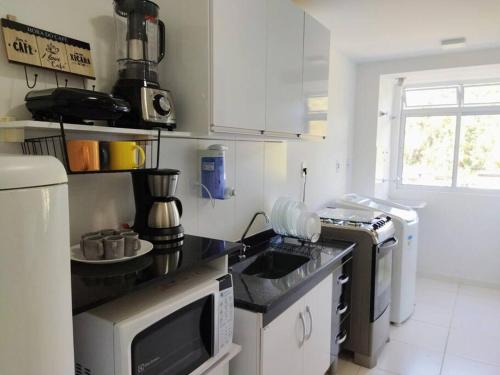 Bom SucessoにあるApartamento em condomínio Nogueira Petrópolis Rj #1のシンクと電子レンジ付きのキッチン