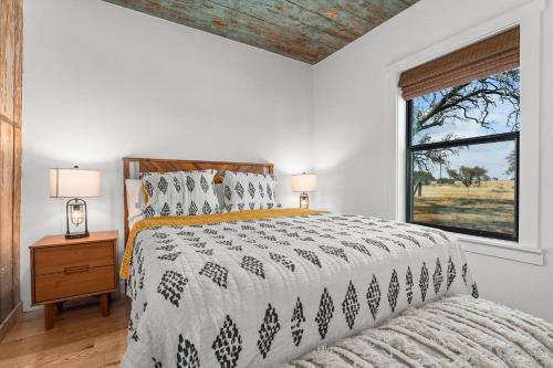 a bedroom with a large bed and a window at Ab Astris - Starry Night Cottage 1 in Stonewall