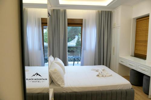 a hotel room with a bed and a mirror at BlackMountain Hotel in Kolgecaj
