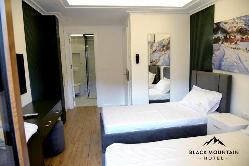 a hotel room with two beds and a mirror at BlackMountain Hotel in Kolgecaj