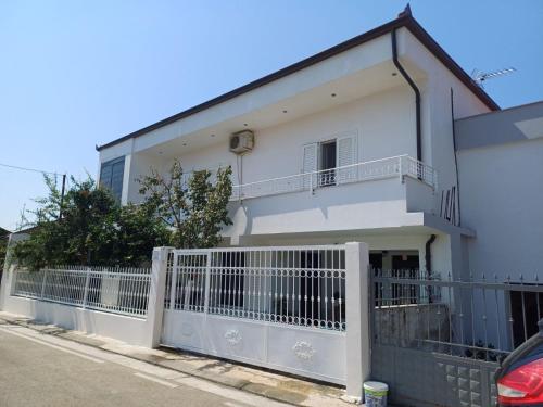 a white house with a white fence at The White House in Divjakë