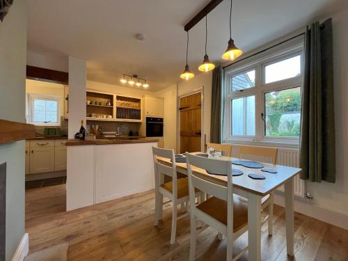 a kitchen and dining room with a table and chairs at One Jubilee Cottages in Shugborough