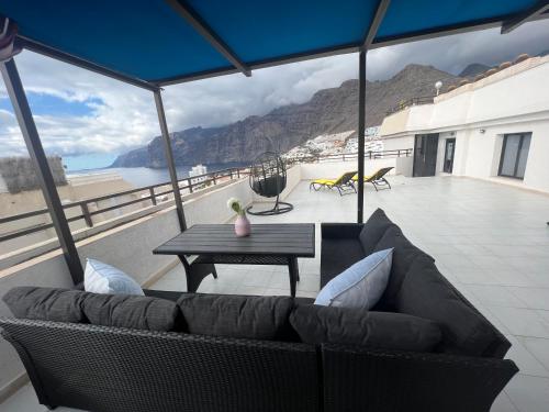 プエルト・デ・サンティアゴにあるRoom in 4 bedroom penthouse with stunning patioのソファとテーブルのあるリビングルーム