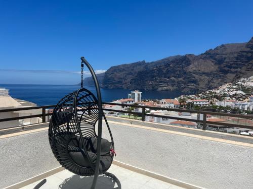 プエルト・デ・サンティアゴにあるRoom in 4 bedroom penthouse with stunning patioの海を見下ろすバルコニーの上に置かれたワイヤーバスケット