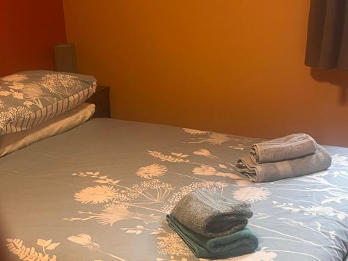 a bed with two towels sitting on top of it at Tumbledown Hotel in Shrewsbury