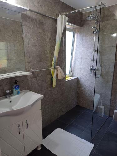 a bathroom with a sink and a shower at The White House in Divjakë