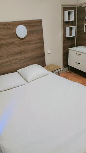 a bedroom with a large white bed with a wooden headboard at Hôtel des 2 Garess in Nevers