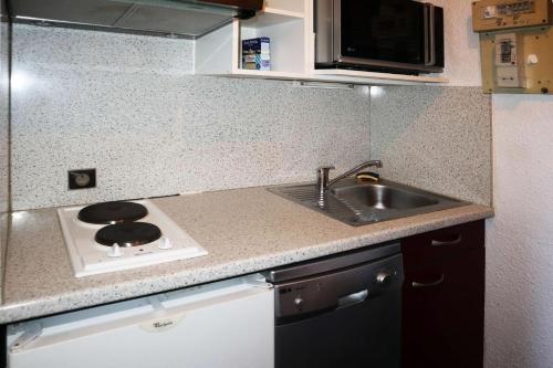 une petite cuisine avec un évier et une cuisinière dans l'établissement Résidence Le Cairn - STUDIO N° 0311 LE CAIRN MAE-4521, aux Orres