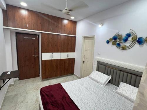 a bedroom with a bed and wooden cabinets at Atlas Homes 1BHK HomeStays in Hyderabad