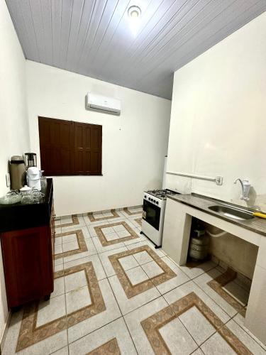 a kitchen with a sink and a stove at Fazenda Oásis do Pará in Santarém