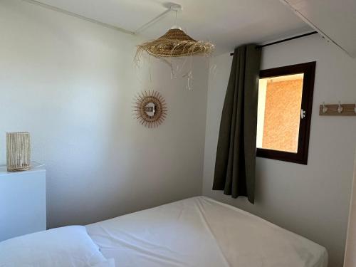 une petite chambre avec un lit et une fenêtre dans l'établissement Studio l Arbanais, à Hyères