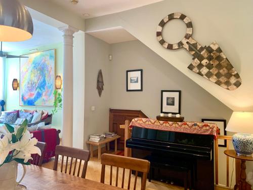 a living room with a table and a piano at 2 bedrooms with one private bathroom in lovely home in New York
