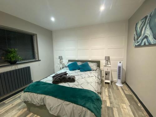 a bedroom with a bed with blue pillows at Rivendell spacious two bedroom 1st floor flat in Kent