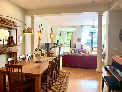a dining room and living room with a table and chairs at 2 bedrooms with one private bathroom in lovely home in New York