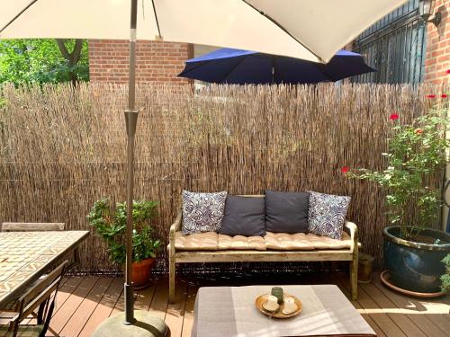 a couch sitting on a patio under an umbrella at 2 bedrooms with one private bathroom in lovely home in New York
