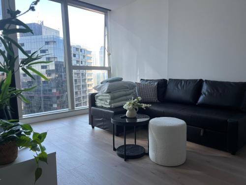 a living room with a black couch and a table at Wsp high rise luxury 2b2b unit in Melbourne