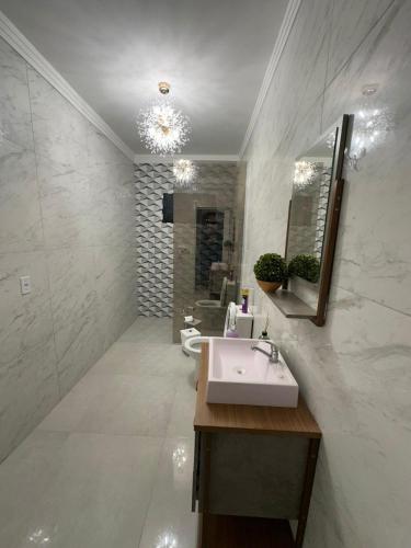 a bathroom with a sink and a mirror and a toilet at Kitnet em Americana SP in Americana