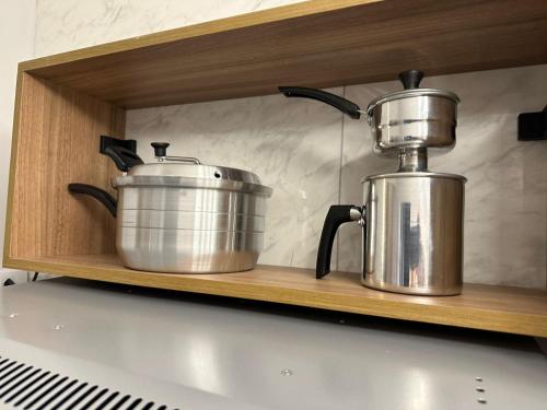 two pots and pans on a shelf in a kitchen at Kitnet em Americana SP in Americana