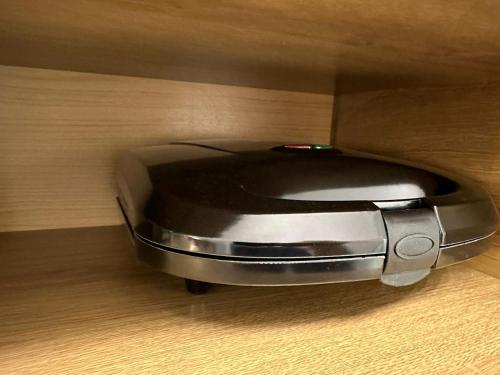 a close up of a toaster sitting on a wooden floor at Kitnet em Americana SP in Americana