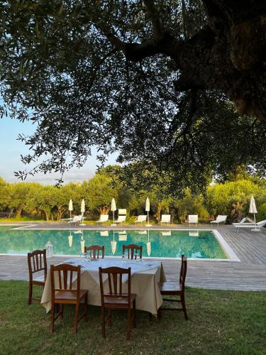a table and chairs in front of a swimming pool at Tenuta Paino in Sessa Aurunca