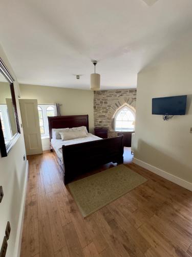 a bedroom with a bed and a couch in a room at Cross Hands Hotel in Llanybydder
