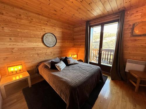 une chambre avec un lit dans une cabane en bois dans l'établissement Chalet Emelthi - CHALET EMELTHI Tout inclus Classé 4 MAE-9351, à Vars