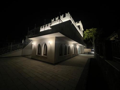 a white building with a balcony at night at The Castle of Etna in Trecastagni